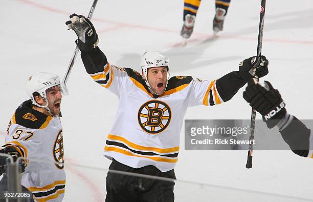 Patrice Bergeron and Marco Sturm of the Boston Bruins celebrate Bergeron's goal in overtime to defeat the Buffalo Sabres at HSBC Arena on November...