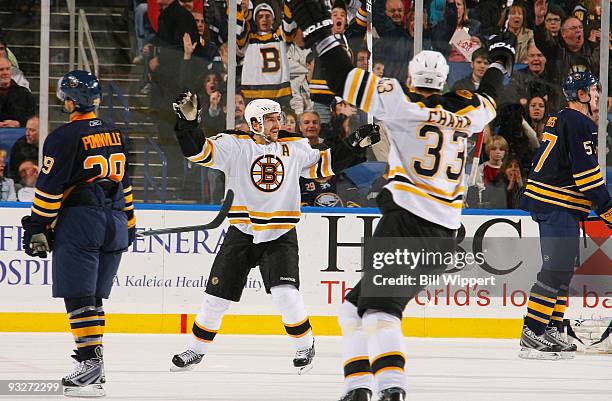 Patrice Bergeron of the Boston Bruins celebrates his game winning overtime goal with teammate Zdeno Chara against the Buffalo Sabres on November 20,...