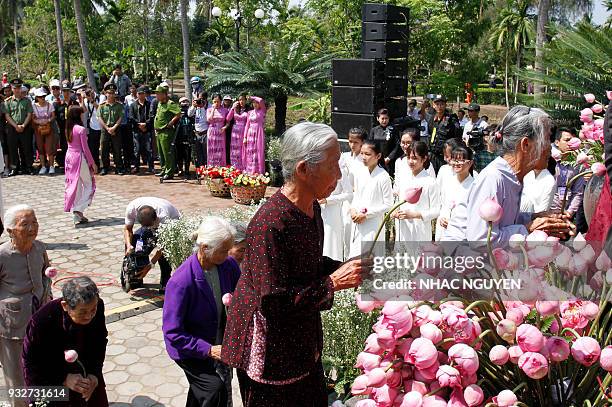 Vietnamese survivors of the My Lai massacre offer flowers at a war memorial in the village of Son My during a ceremony marking the 50th anniversary...