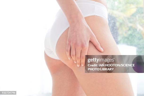 woman massaging buttock - bottom stock pictures, royalty-free photos & images