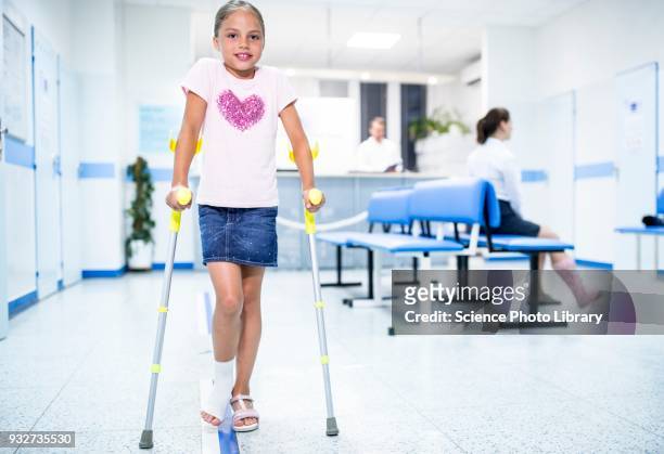 girl walking with crutches - crutches stockfoto's en -beelden