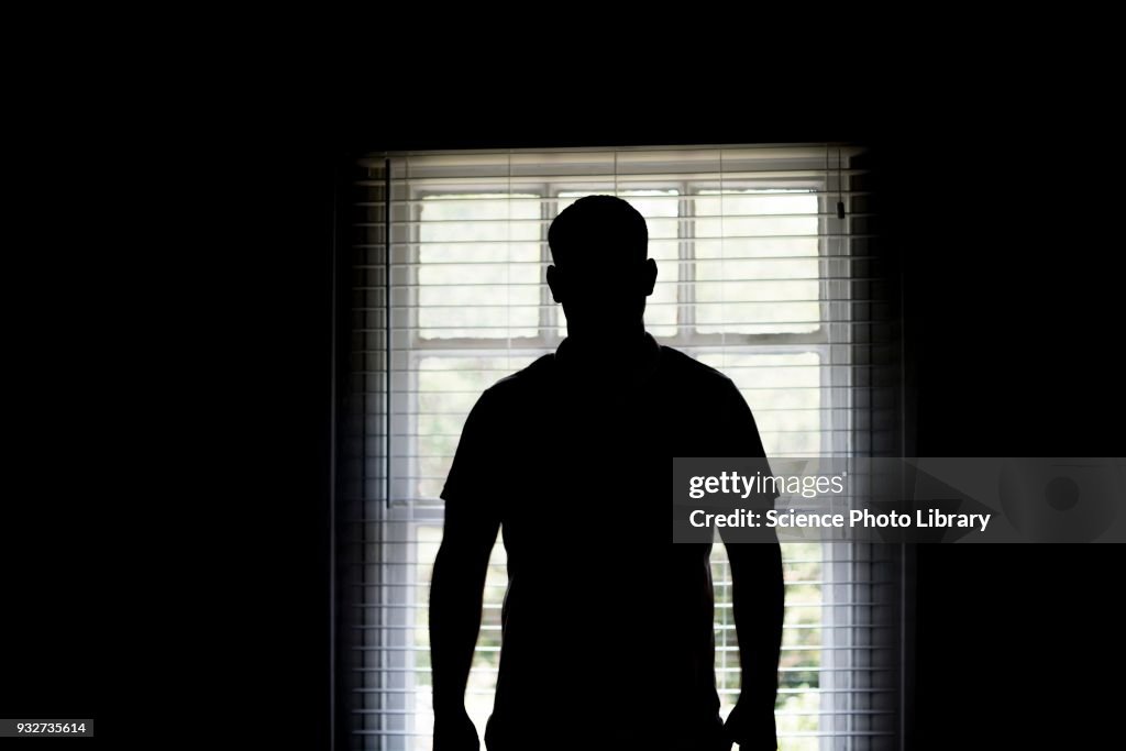 Silhouette of a man by a window