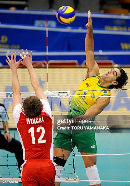 Gilberto Godoy Fiho of Brazil spikes the ball over Pawel Woicki of Poland during their match at the men's Grand Championship Cup volleyball...