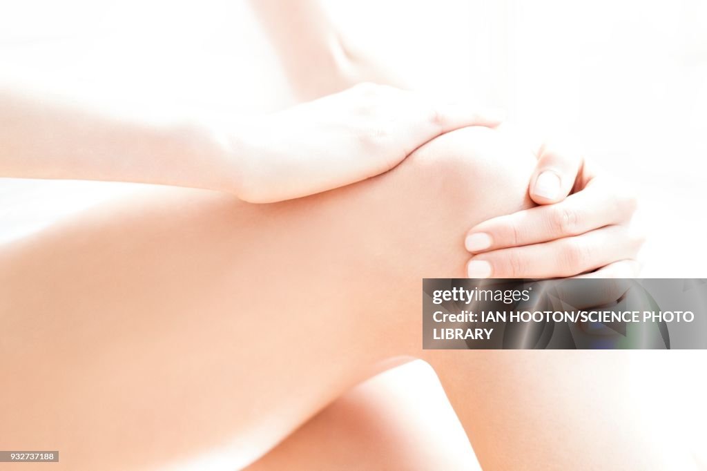 Woman rubbing her sore knee