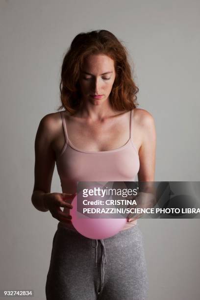 young woman holding inflated balloon - belly stock pictures, royalty-free photos & images