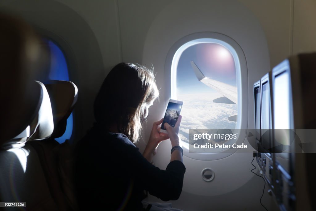 Girl taking photo out of airplane window