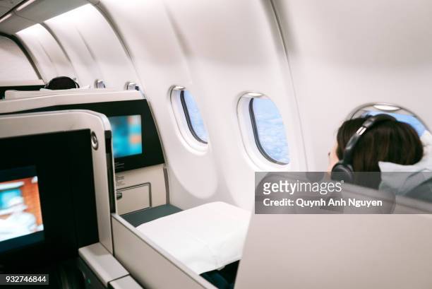 passenger using on board entertainment on business class of  aircraft - first class flight stock pictures, royalty-free photos & images