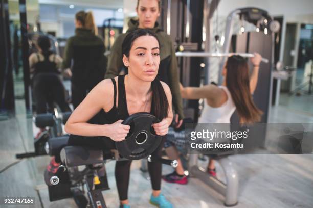 personal trainer supervising girl on roman bench - group of people flexing biceps stock pictures, royalty-free photos & images