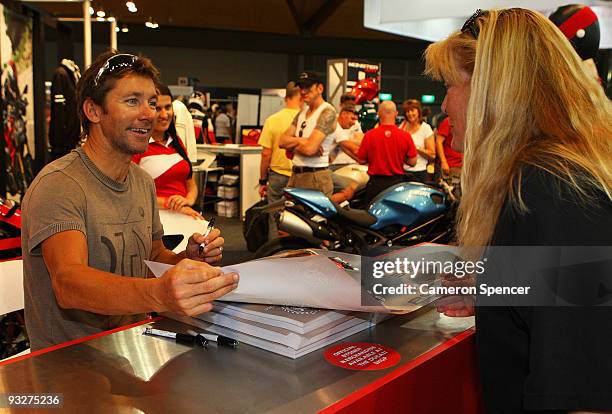Former World Superbike champion Troy Bayliss signs autographs at the Ducati stand during the Australian Motorcycle Expo at Sydney Olympic Park on...