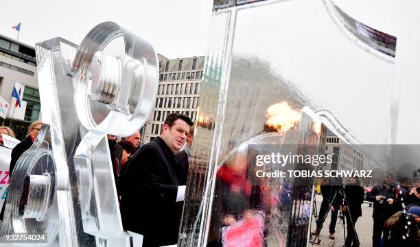 The new German Labour Minister Hubertus Heil melts an ice sculpture featuring "21 percent" to set a sign against the salary gap between female and...