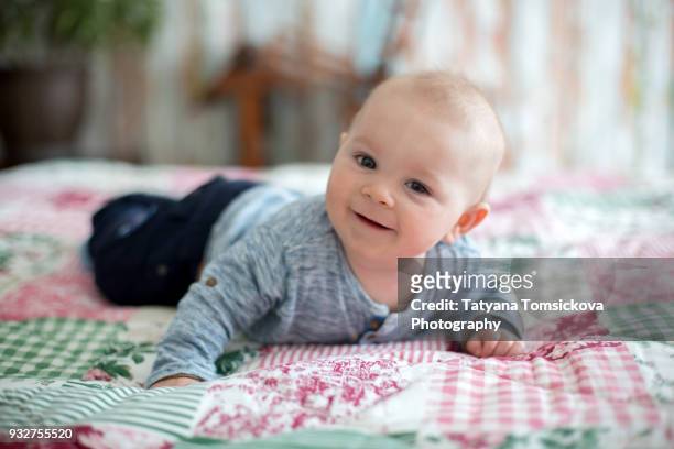 cute little smiling newborn baby boy, playing in the morning, baby activity - baby touching belly fotografías e imágenes de stock