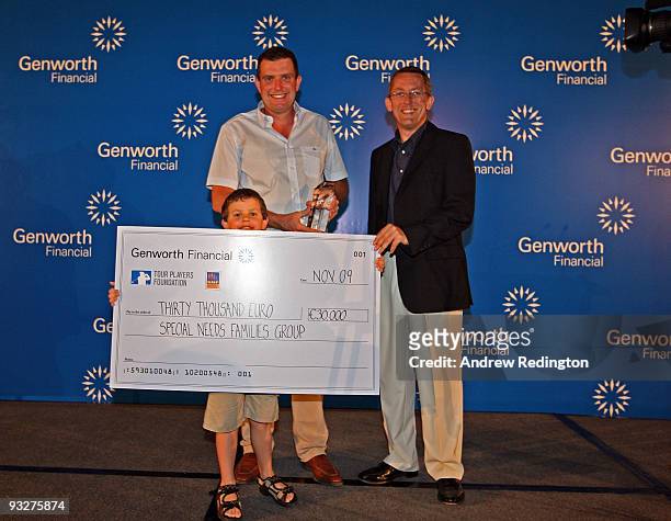 Anthony Wall of England and his son pose with a charity cheque alongside Peter Barrett, MD of Genworth, at the Genworth Financial Statistics Awards...