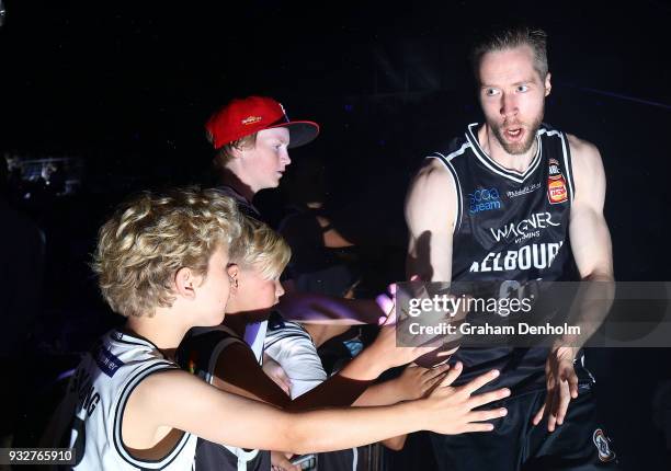 David Barlow of Melbourne United greets young fans as he runs out onto the court during game one of the NBL Grand Final series between Melbourne...