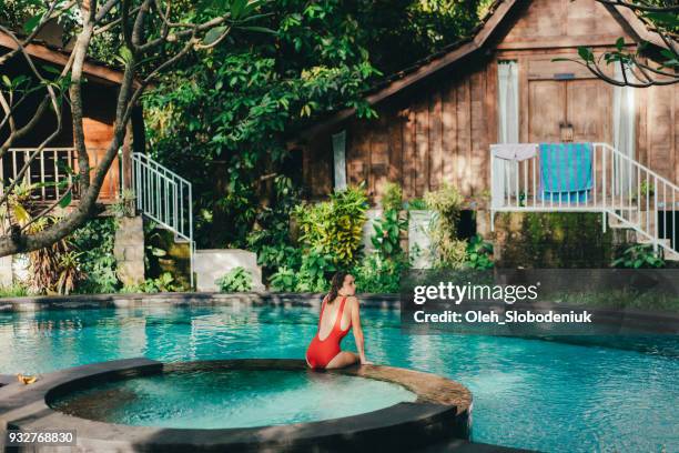 woman in the red swimsuit in swimming pool - bali spa stock pictures, royalty-free photos & images