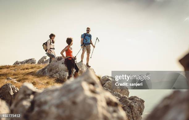 small group of people standing on top of hill - praticando imagens e fotografias de stock