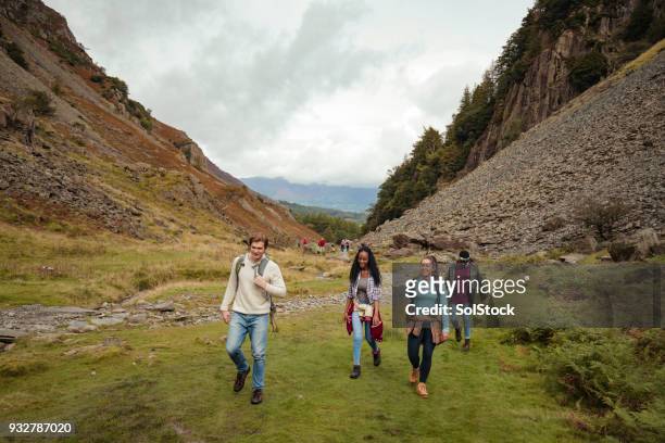 walking up the hillside - people climbing walking mountain group stock pictures, royalty-free photos & images