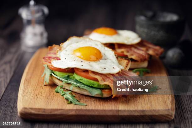 gezonde spek, gebakken ei brunch - avocado toast stockfoto's en -beelden