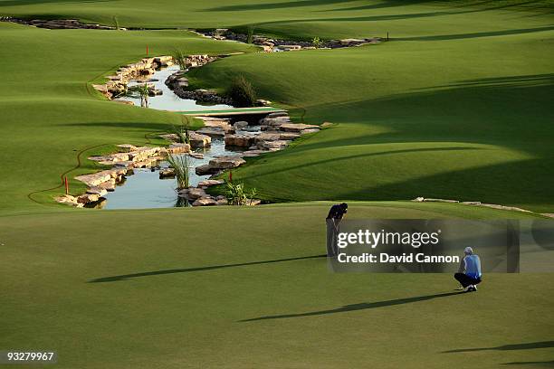 Padraig Harrington of Ireland watches his playing partner Camilo Villegas of Colombia hole out at the 18th hole during the third round of the Dubai...