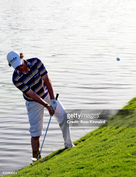 Rory McIlroy of Northern Ireland plays from the water on the 16th hole during the third round of the Dubai World Championship on the Earth Course,...