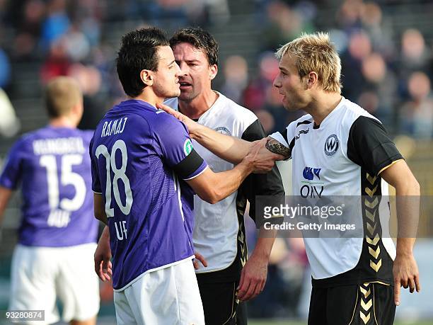 Alban Ramaj of FC Erzgebirge Aue and Christoph Burkhard of SV Wacker Burghausen and Bjoern Hertl of SV Wacker Burghausen argue during the 3. Liga...