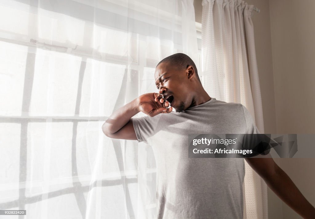 Businessman fresh out of bed getting up for work in the morning.