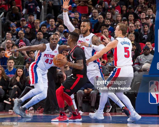 Malcolm Miller of the Toronto Raptors is surrounded by Eric Moreland, Anthony Tolliver and Luke Kennard of the Detroit Pistons in the first half of...