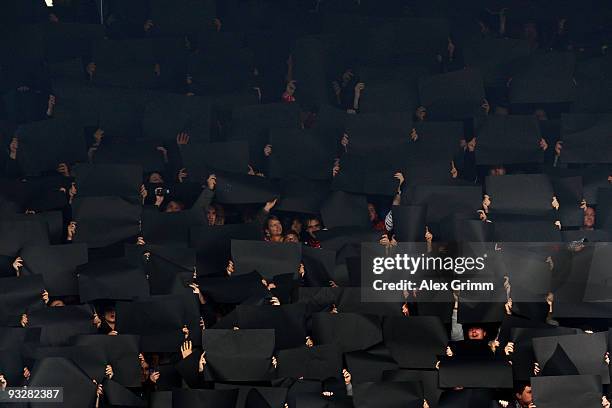 Supporters of Freiburg hold up black placards to commemorate president Achim Stocker, who has died from a heart attack and goalkeeper Robert Enke...