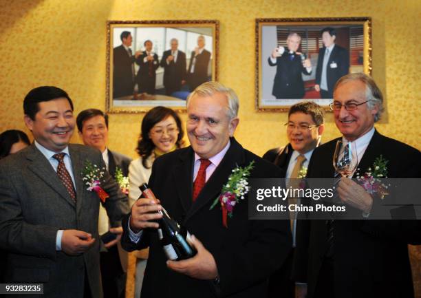 Former French Premier Jean-Pierre Raffarin looks at a bottle of red Lafite at the inauguration ceremony of Baomalong International Wine Shop on...