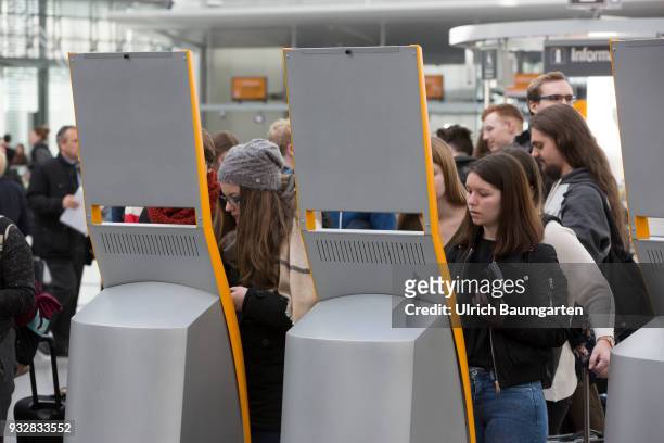 Munich Airport - passengers checking in at check in vending machines of Lufthansa.