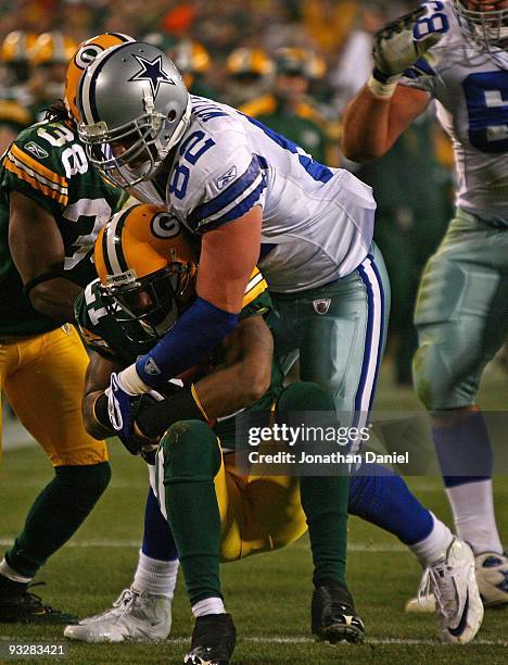 Jason Witten of the Dallas Cowboys tackles Charles Woodson of the Green Bay Packers after Woodson intercepted a pass at Lambeau Field on November 15,...