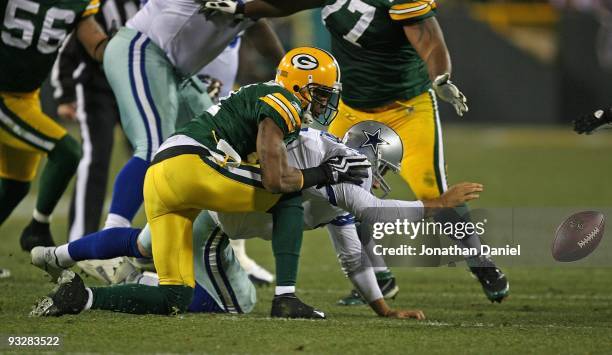 Tony Romo of the Dallas Cowboys reaches for the ball after fumbling while being sacked by Charles Woodson of the Green Bay Packers at Lambeau Field...