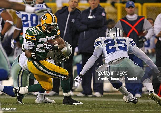 Ryan Grant of the Green Bay Packers fights off a tackler as Patrick Watkins of the Dallas Cowboys closes in at Lambeau Field on November 15, 2009 in...