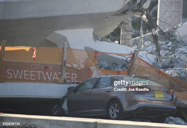 Car is seen stuck under the rubble as law enforcement and members of the National Transportation Safety Board investigate the scene where a...