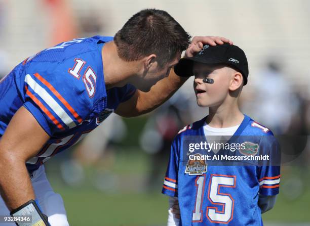 Quarterback Tim Tebow of the Florida Gators talks with with eight-year-old Jackson White before play against the Florida International University...