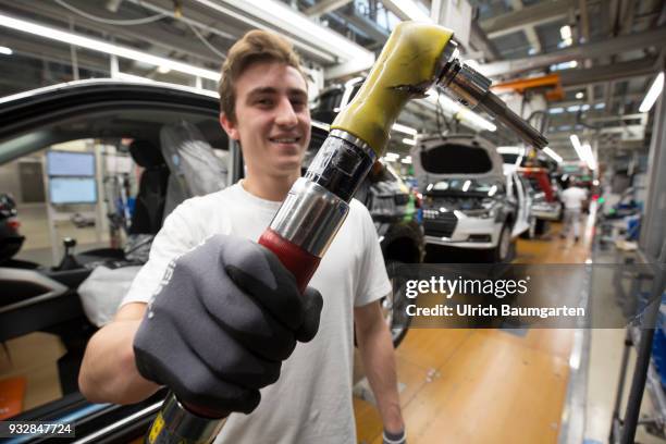 Car production at Audi AG in Ingolstadt. Installation of the front seats on the Audi A3/Q2 - worker with mounting key.