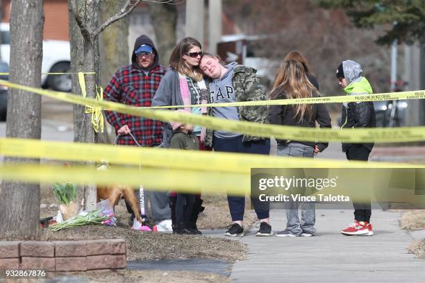 Friends and nearby residents, Jennifer and her daughter Kyla Sampson and other family members lay flowers near the home where a 39-year-old woman and...