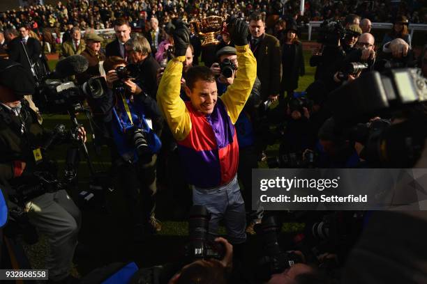 Richard Johnson holds the Gold Cup after riding Native River to victory in the Timico Cheltenham Gold Cup Chase at the Cheltenham Festival at...