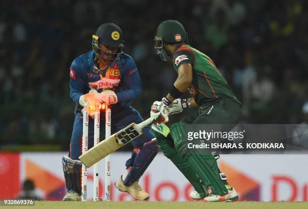 Sri Lankan wicketkeeper Kusal Perera attempts to stump Bangladesh cricketer Sabbir Rahman during the sixth Twenty20 international cricket match...