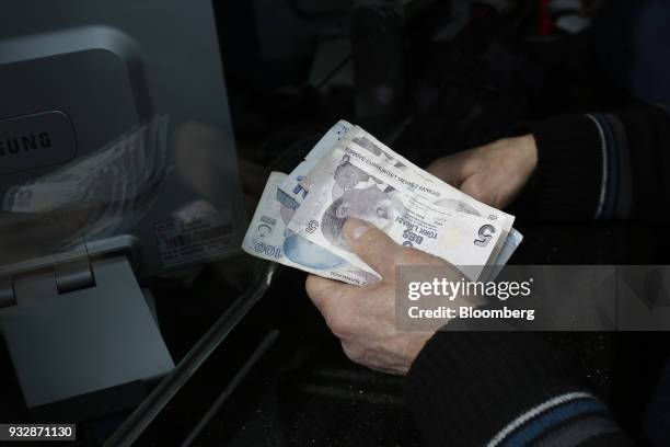 Customer counts Turkish lira banknotes at a currency exchange in Istanbul, Turkey, on Friday, March 16, 2018. As Turkish markets tumble, investor...