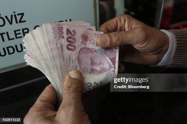 Customer counts Turkish lira banknotes at a currency exchange in Istanbul, Turkey, on Friday, March 16, 2018. As Turkish markets tumble, investor...