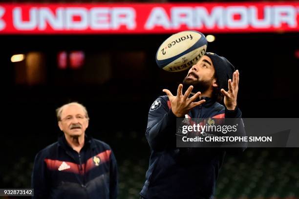 Newly selected player Yoann Huget practices as French coach Jacques Brunel looks on during the captain run at the Millenium stadium, in Cardiff on...