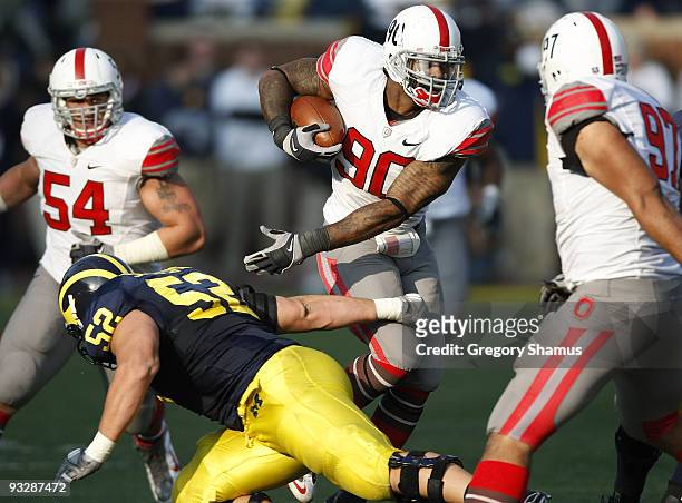 Thaddeus Gibson of the Ohio State Buckeyes tries to avoid the tackle of Stephen Schilling of the Michigan Wolverines after a fourth quarter...