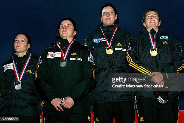 Janine Tischer, Sandra Kiriasis, Romy Logasch and Cathleen Martini of Germany stand for their National Anthem on the winner's podium after the 2-man...