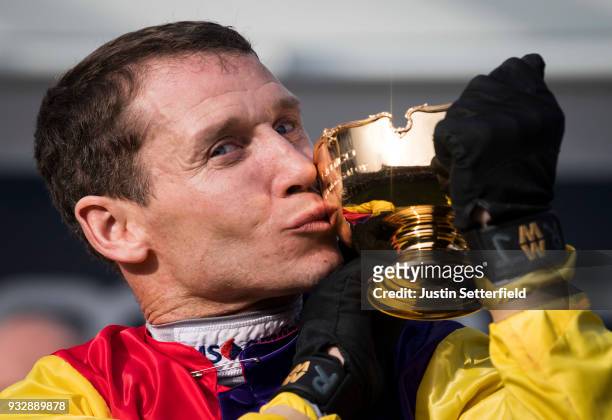 Richard Johnson holds the Gold Cup after riding Native River to victory in the Timico Cheltenham Gold Cup Chase at the Cheltenham Festival at...