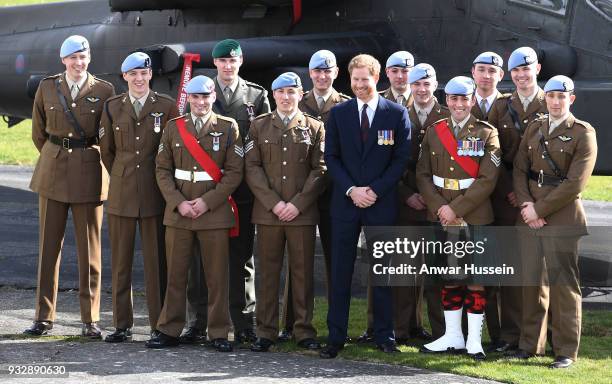 Prince Harry poses in front of an Apache helicopter with Army Air Corps pilots after presenting Wings during a ceremony at Museum of Army Flying in...