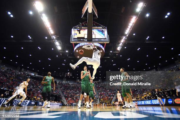 Shaquille Morris of the Wichita State Shockers dunks against Ajdin Penava of the Marshall Thundering Herd in the first half during the first round of...