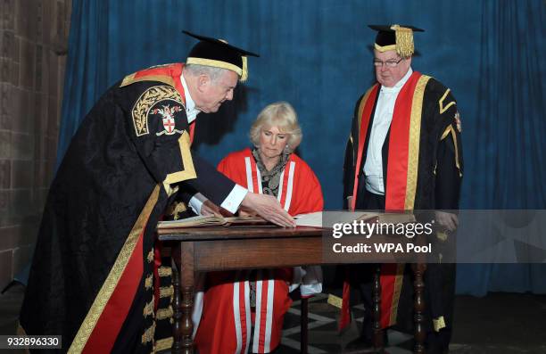 Camilla, Duchess of Cornwall signs a visitors' book after receiving her honorary doctorate from the Chancellor of the University of Chester Gyles...