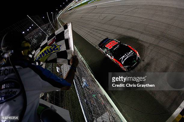Kyle Busch, driver of the Z-Line Designs Toyota, crosses the finish line to win the NASCAR Nationwide Series Championship and the Ford 300 at...