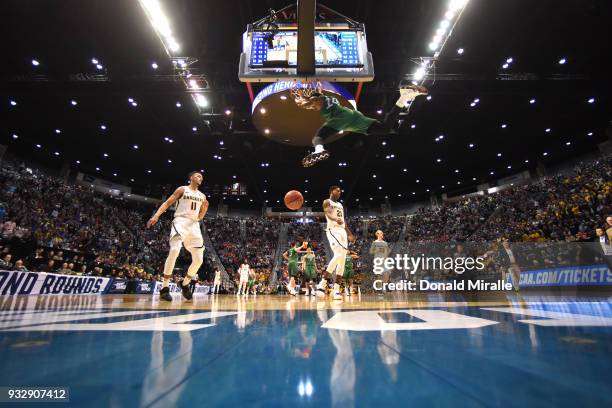 Burks of the Marshall Thundering Herd dunks in the second half against Landry Shamet of the Wichita State Shockers during the first round of the 2018...