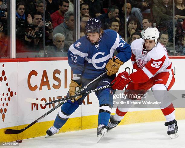 Ryan White of the Montreal Canadiens and Jonathan Ericsson of the Detroit Red Wings battle for the puck during the NHL game on November 21, 2009 at...